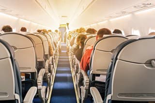 Commercial aircraft cabin with rows of seats down the aisle. morning light in the salon of the airliner. economy class