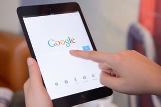 "stanbul, Turkey - January 25, 2013: Womans hands holding a iPad Mini displaying Google Application in a coffee shop. iPad is a touchscreen tablet pc produced by Apple Inc."