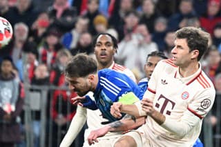 Na snímke sprava Thomas Müller (Bayern) a kapitán Guram Kašia (Slovan) bojujú o loptu počas zápasu.