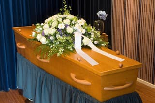 A coffin with flower arrangement in a morgue