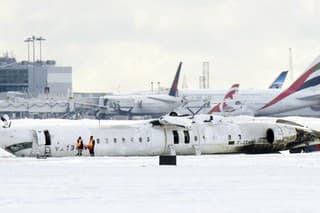 Lietadlo spoločnosti Delta Air Lines leží prevrátené na zasneženej asfaltovej ploche na Pearsonovom medzinárodnom letisku v Toronte.