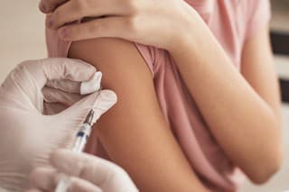 Close up of unrecognizable doctor vaccinating child in medical clinic, copy space