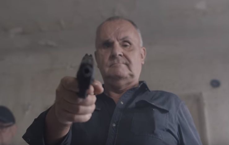 Ráž mieri pištoľou do tváre novinárovi.