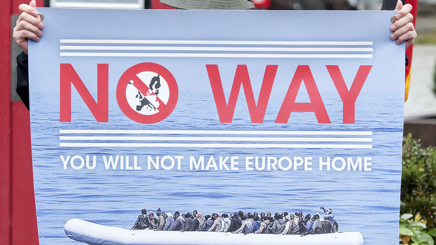 Muž drží plagát s jasným odkazom migrantom: ,,Z Európy si domov nespravíte."