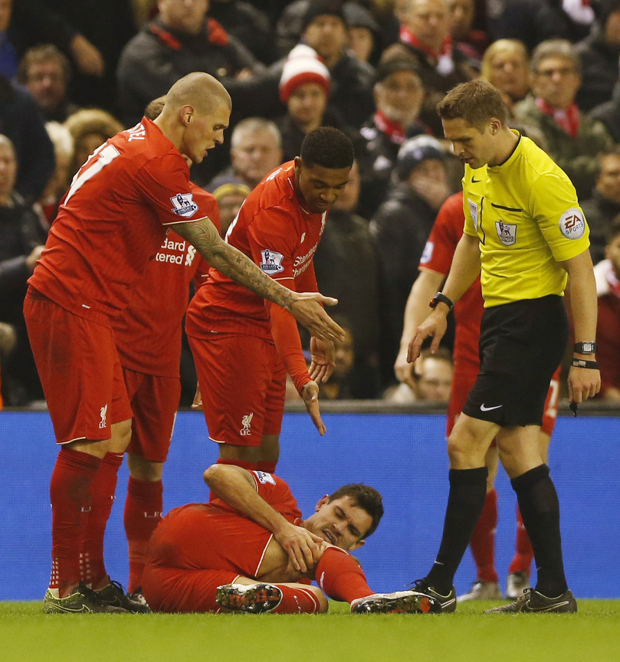 Zranený Dejan Lovren leží na trávniku.