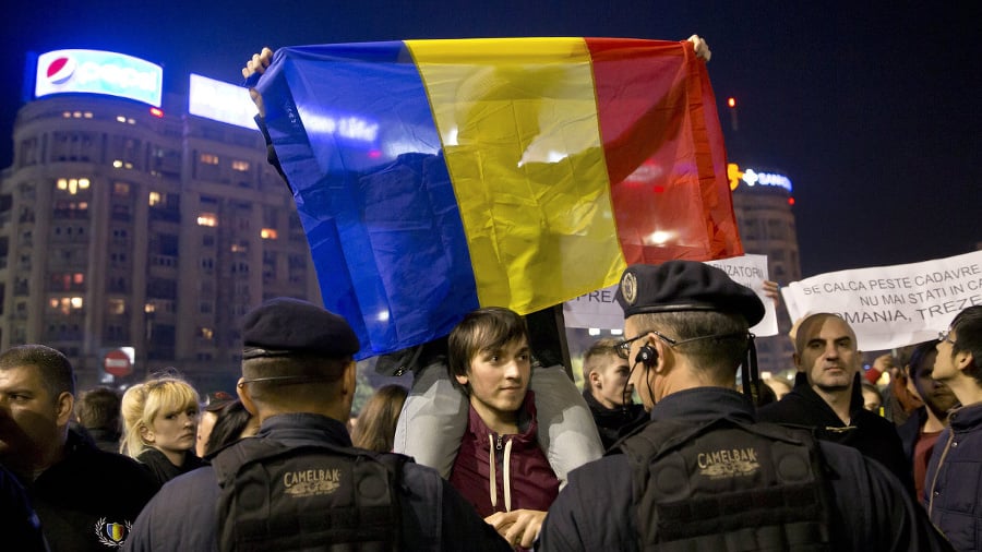 Demonštrant drží rumunskú zástavu