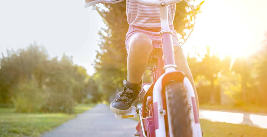 Low section of girl riding bicycle in park.