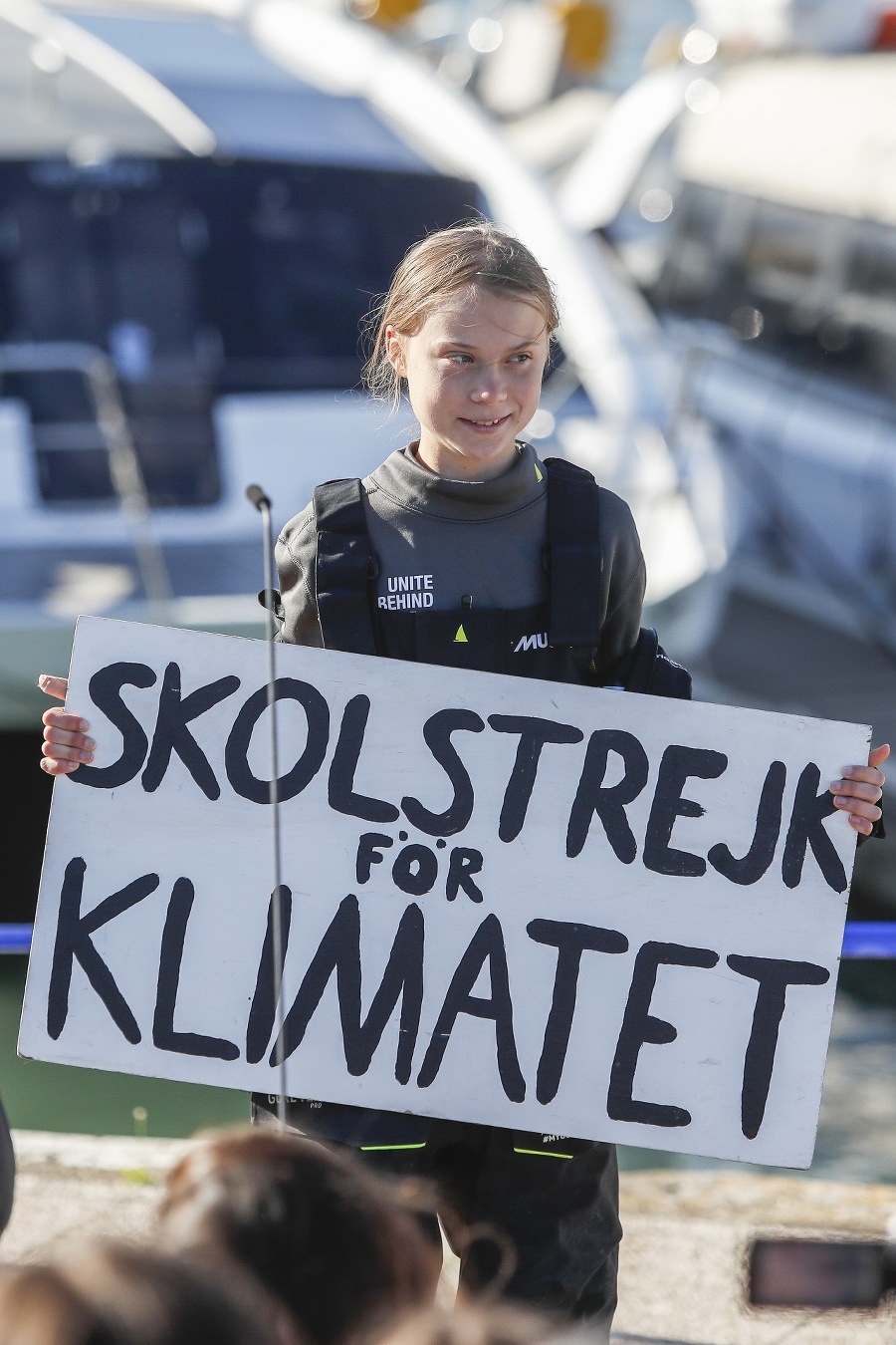 Greta Thunbergová drží trasparent