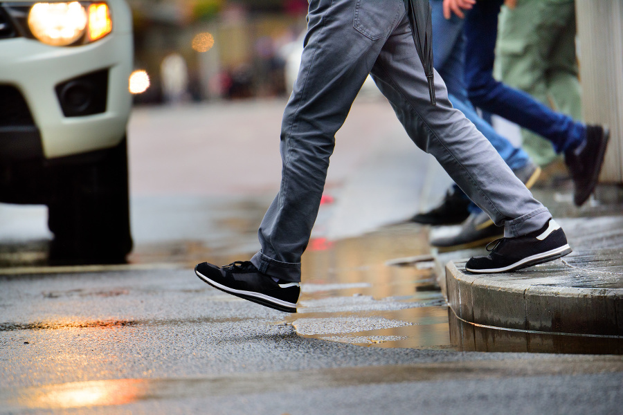 Man stepping over puddle