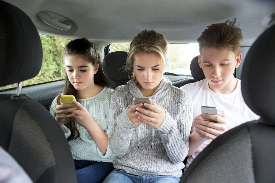 Three teenagers text messaging