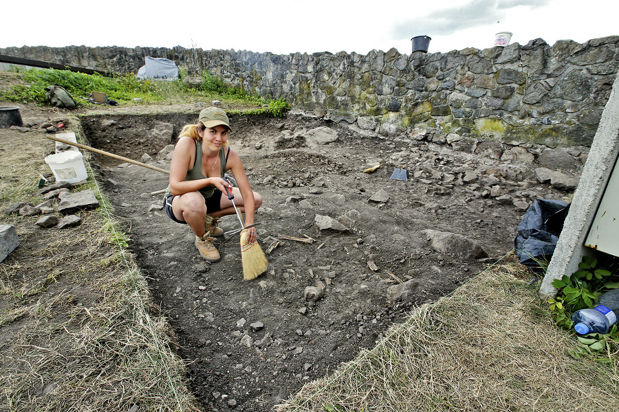 Mladá archeologička ukazuje miesto,