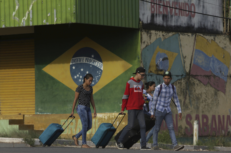 Mladí Venezuelčania ťahajú kufre