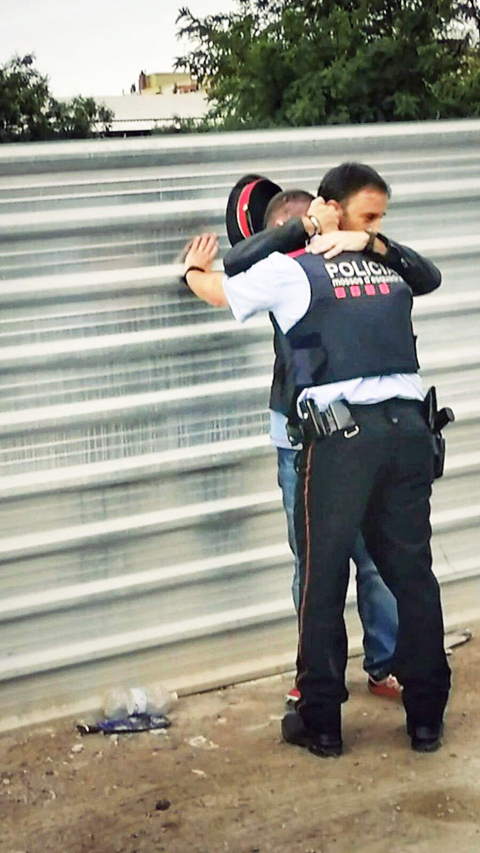 Katalánsky policajt objíma demonštranta.
