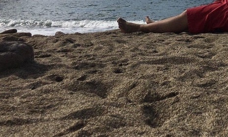 Muž zaspal na pláži