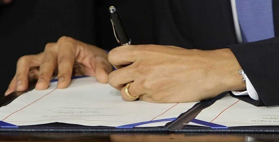 Barack Obama pri podpisovaní