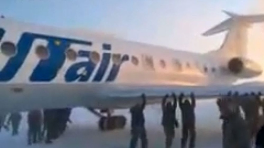 Pasažieri zamrznuté lietadlo potlačiť.