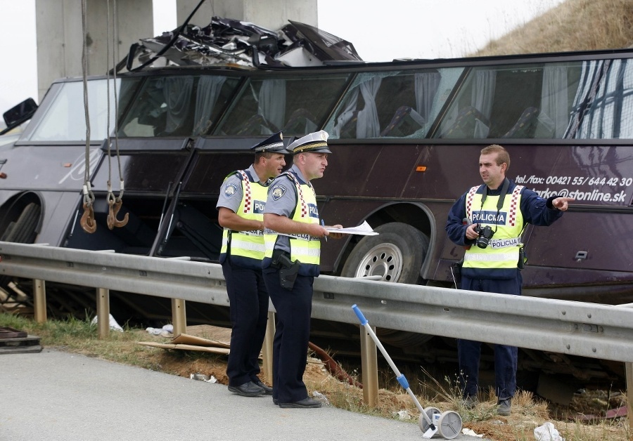 Chorvátski policajti skúmajú vrak slovenského autobusu.