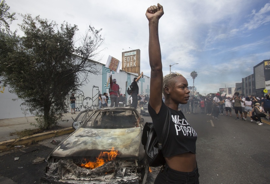 Protestujúca pózuje vedľa zhoreného