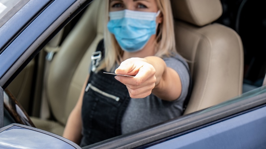 Woman driving a Car and Showing documents for COVID-19 restrictions control