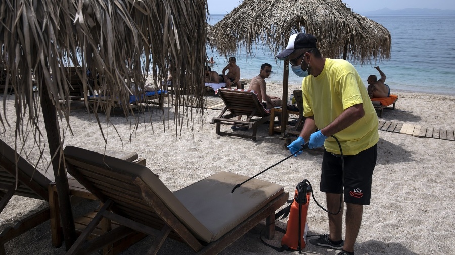 Zamestnanec pláže dezinfikuje lehátka