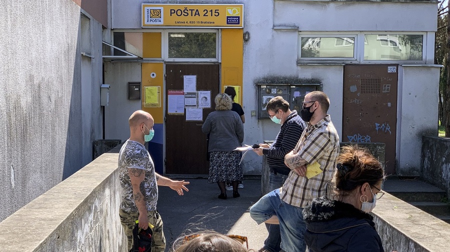 Ľudia čakajúci pred poštou