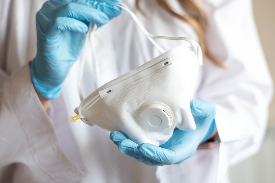 Nurse wearing respirator mask holding a positive blood test
