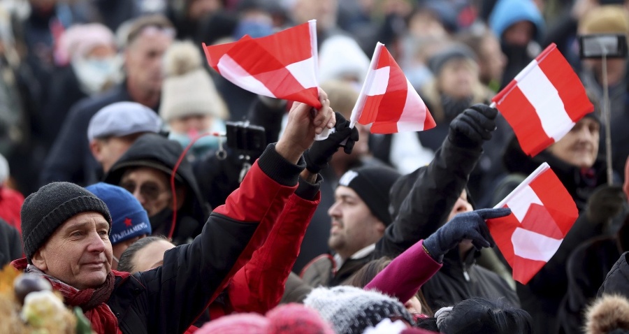 Protestujúci mávajú rakúskymi vlajkami