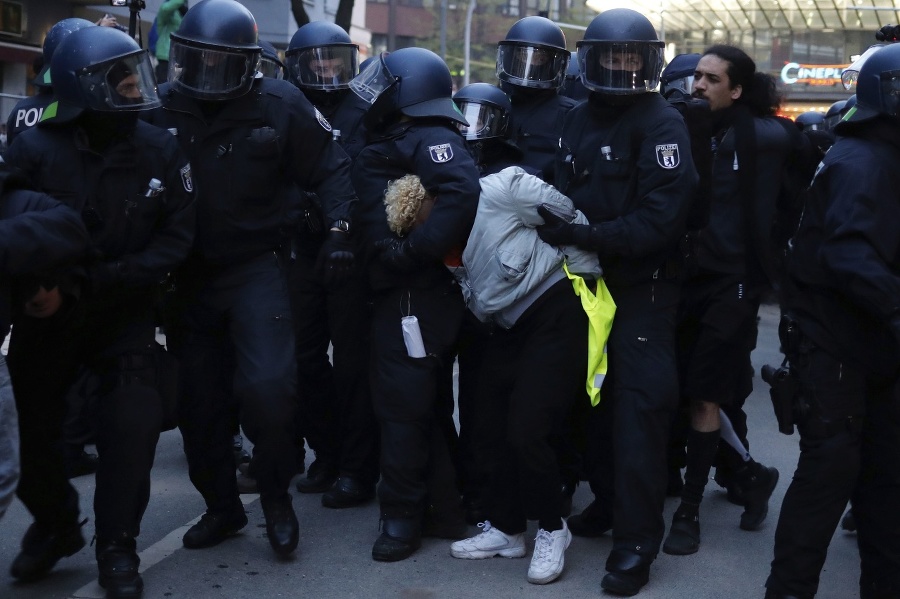 Policajti zadržujú demonštranta počas
