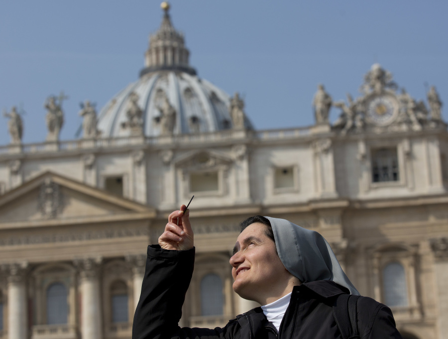 Mníška Mira z Albánska sleduje čiastočné zatmenie Slnka na Námestí sv. Petra vo Vatikáne 20.  marca 2015.
