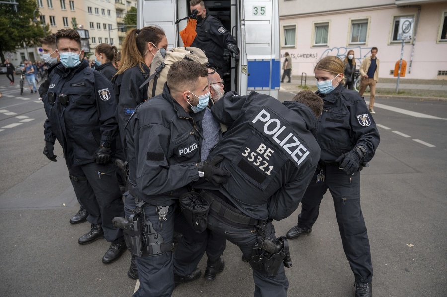 Policajti zatýkajú demonštranta počas