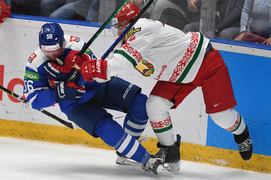 Slovenský hokejista Marko Daňo (vľavo) a hráč Bieloruska Jevgenij Lisovec bojujú pri mantineli v  poslednom zápase D-skupiny Slovensko - Bielorusko na kvalifikačnom turnaji o postup na ZOH2022 v Pekingu