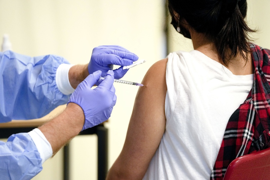 Lekár očkuje študentku vakcínou