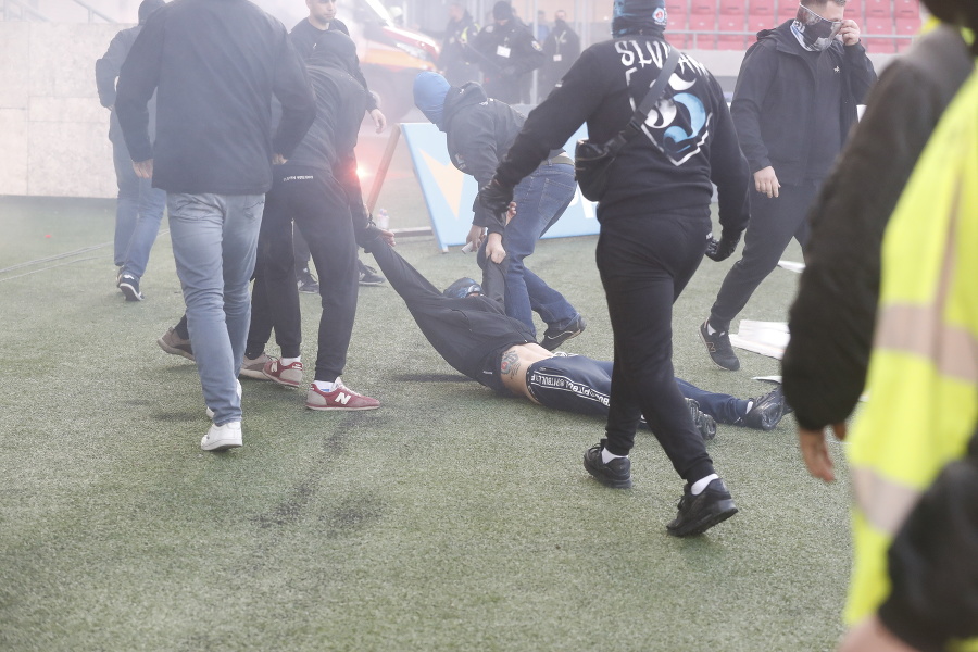 Fanúšikovia vtrhli na trávnik a priamo na hracej ploche sa začali surovo mlátiť.