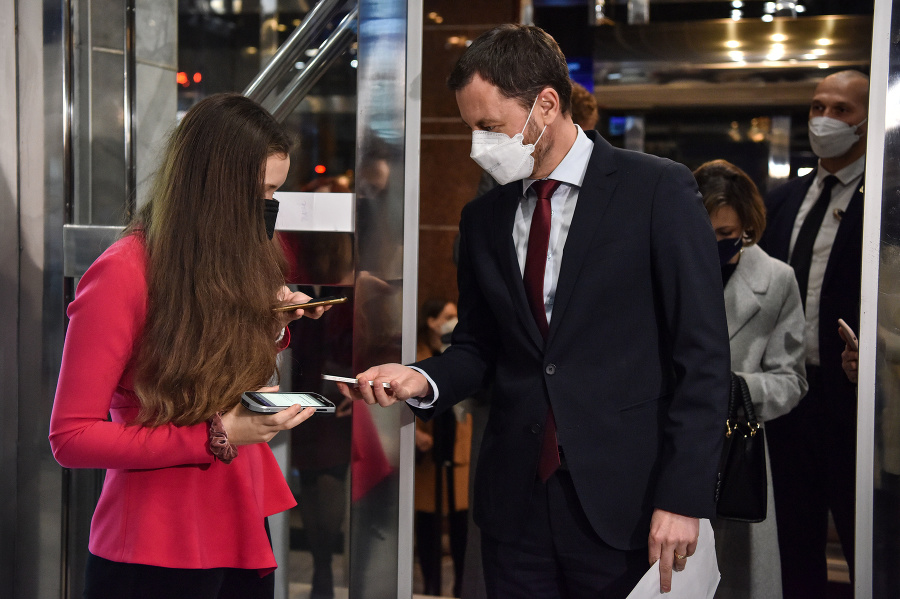 Na snímke predseda vlády SR Eduard Heger (vpravo) sa preukazuje Covid passom pri vstupe do Divadla Nová scéna na predstavenie Bedári v Bratislave.