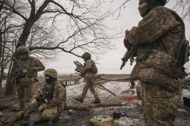 Ukrajinský vojak nesie konáre