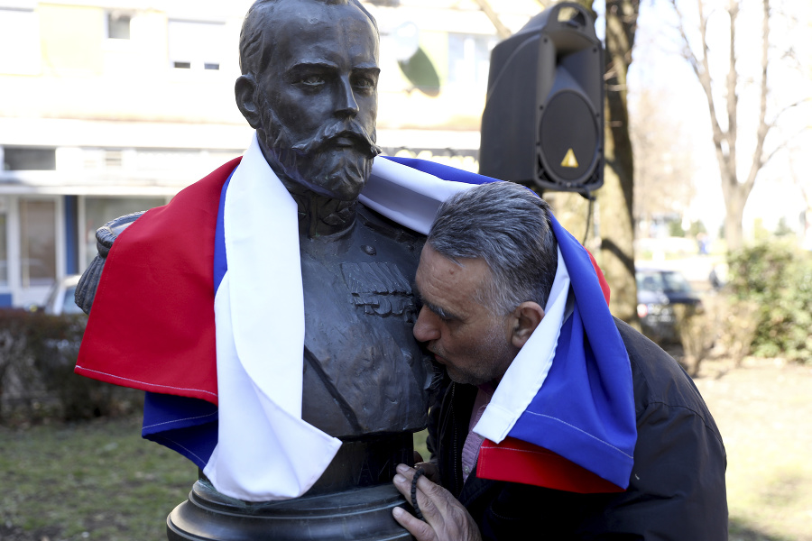 Demonštrant bozkáva sochu ruského cára Mikuláša II. počas zhromaždenia v Banja Luke v Bosne v sobotu 12. marca 2022.