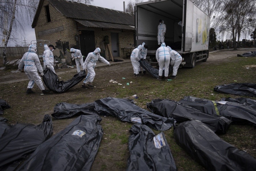 Buča, Ukrajina: Pracovníci nakladajú telá obetí do nákladného auta.