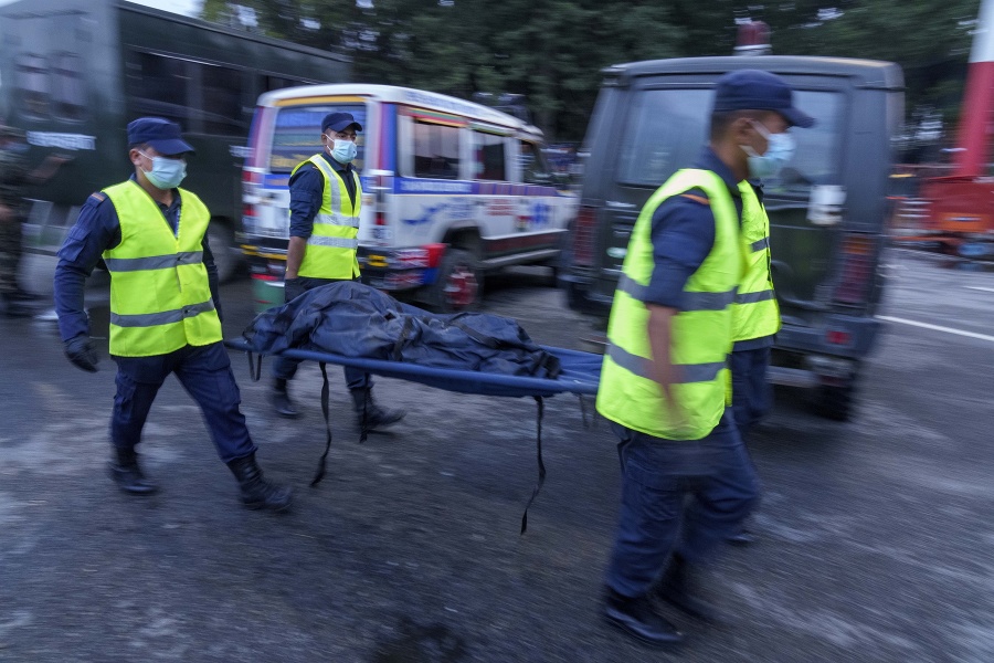 Nepálski policajti prenášajú telo