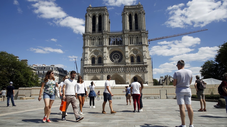 Ľudia kráčajú po nádvorí katedrály Notre Dame.