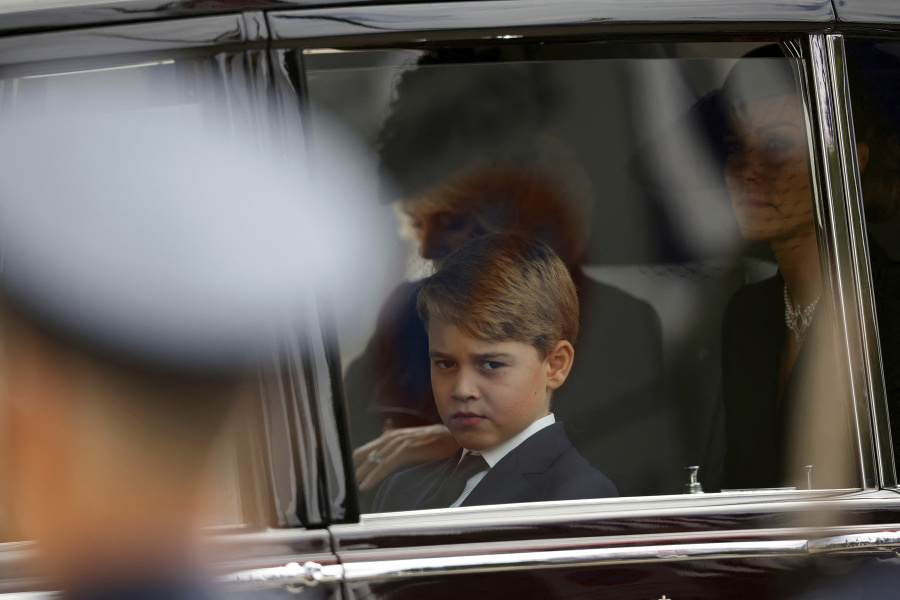 Kate, princezná z Walesu a princ George sedia v aute zatiaľ čo rakvu kráľovnej Alžbety II. odnášajú.