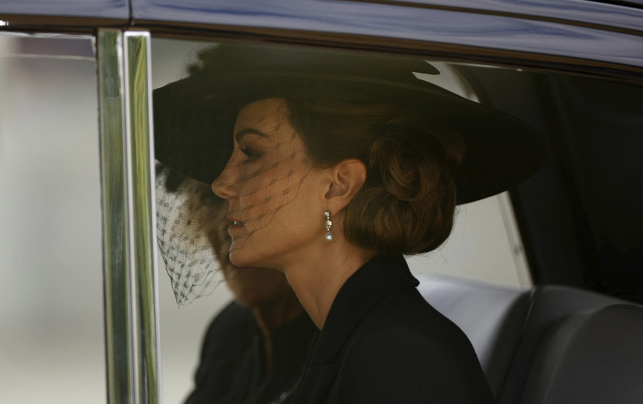 Kate, princezná z Walesu, sedí v aute, zatiaľ čo rakvu kráľovnej Alžbety II. prenášajú.