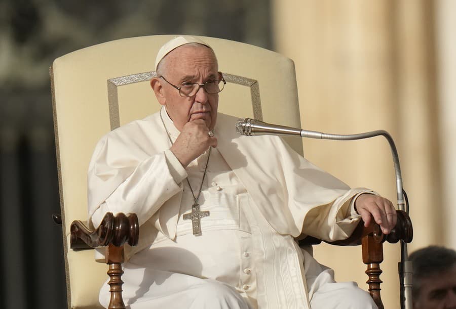 Pápež František sedí počas