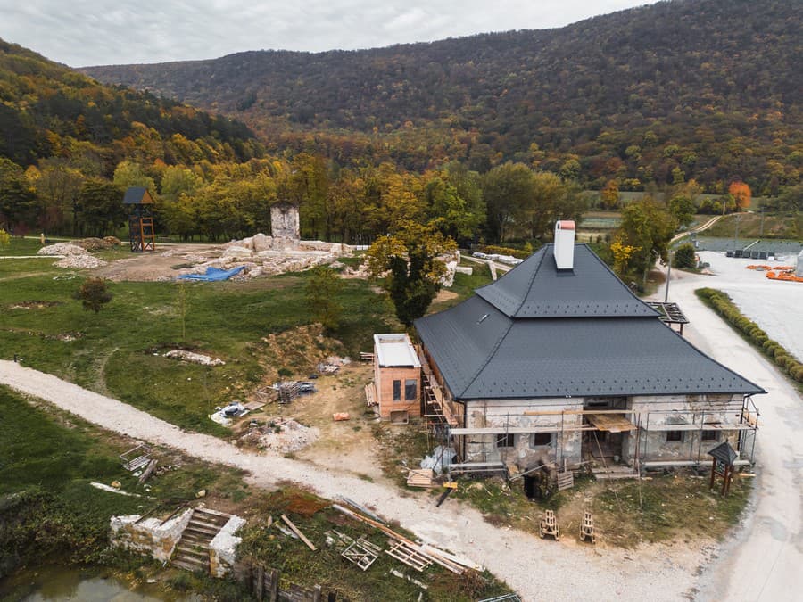 Pohľad z dronu na areál s ruinami Pavlínskeho kláštora a rozhľadňou, v ktorom rekonštruujú aj Andrássyovskú kúriu a dokončujú novú ubytovňu.