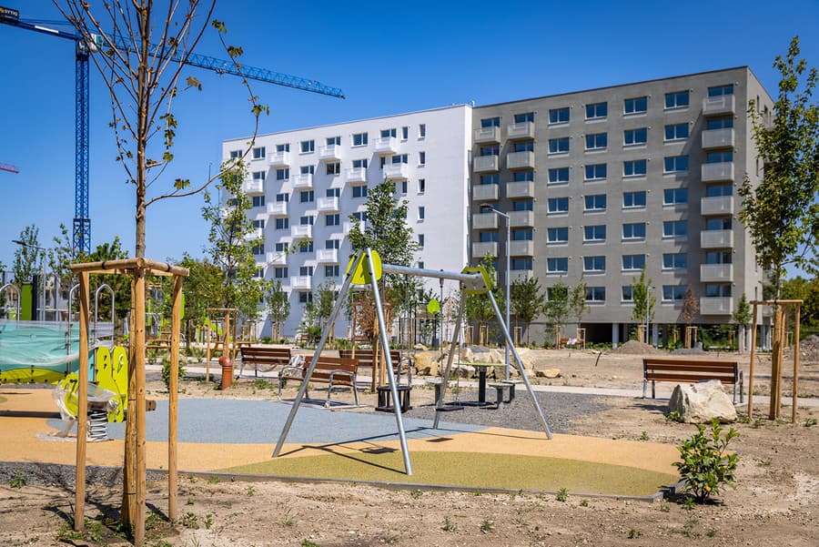 Pri projekte rastie zelený park s lavičkami a detským ihriskom.
