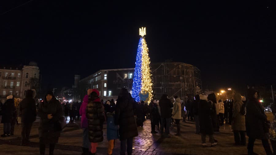 Ľudia počas rozsvietenia vianočného stromčeka vo farbách ukrajinskej národnej zástavy v Kyjeve 19. decembra 2022.
