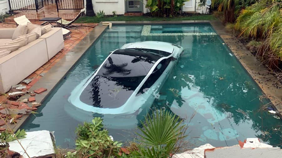 Auto značky Tesla skončilo v bazéne za múrom, ktorý vodička prerazila.