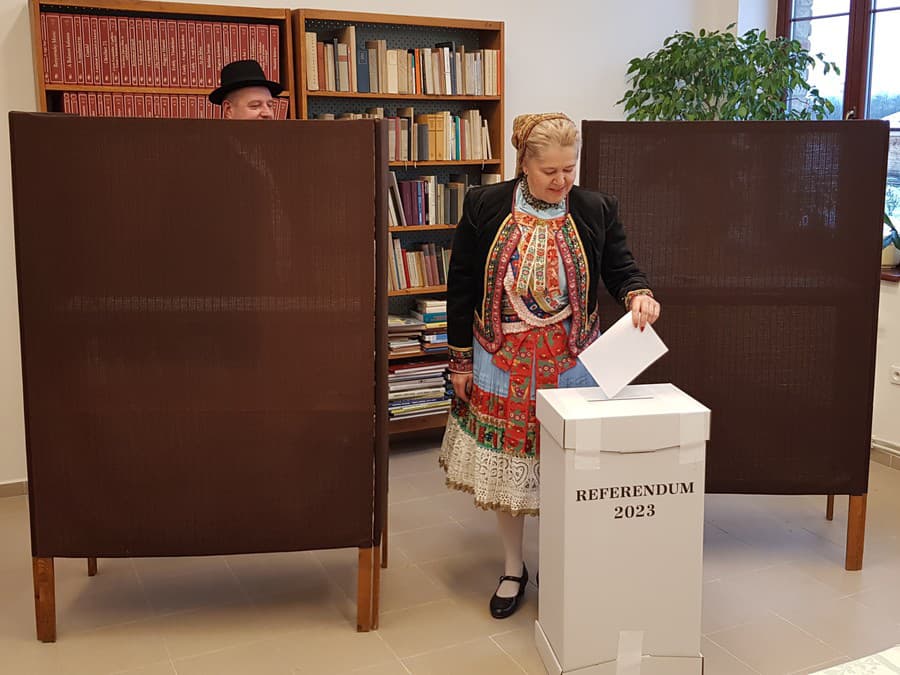 Na snímke členka folklórneho súboru z Martoviec tradične v kroji vhadzuje obálku z hlasovacím lístkom do volebnej schránky.