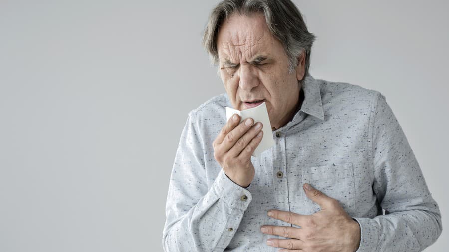 Old man coughing to