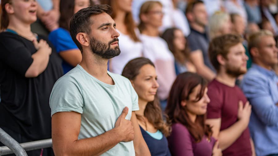 Väčšina ľudí spieva hymnu s rukou na srdci (ilustračné foto).