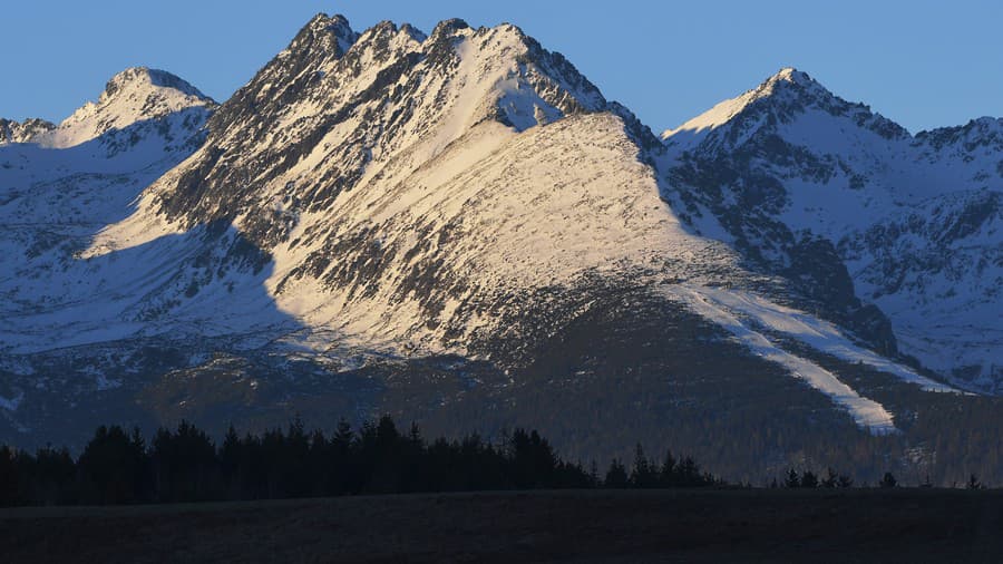 Pohľad na Vysoké Tatry od obce Šuňava, okres Poprad, vľavo Furkotský štít, uprostred Soliskový hrebeň a vpravo Štrbský štít.